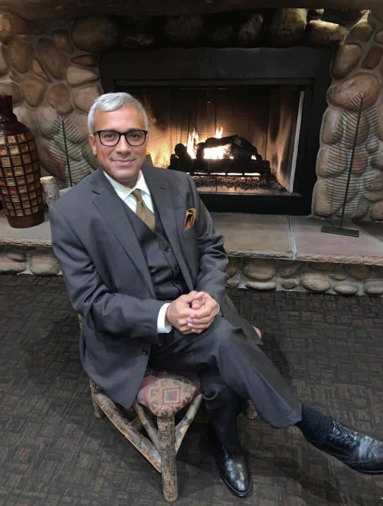 Dr. Ramsis Ghaly sitting by the fireplace
